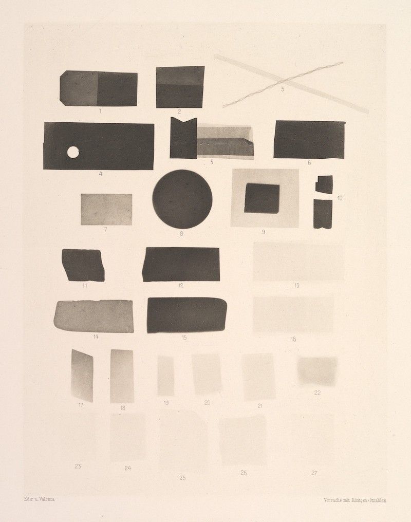 A vintage sepia-toned photograph featuring a collection of abstract, dark shapes arranged on a light background, numbered from 1 to 27, with text at the bottom indicating experiments with X-rays.