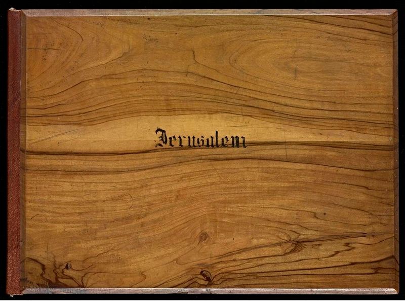 Close-up of a vintage book cover with marbled brown paper and the word 'Jerusalem' in ornate black lettering.