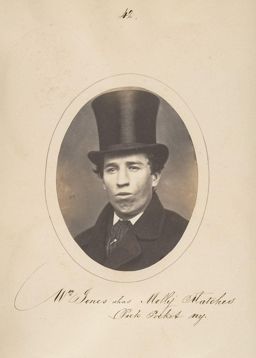 Vintage sepia-toned portrait of a man in a top hat with handwritten text below.