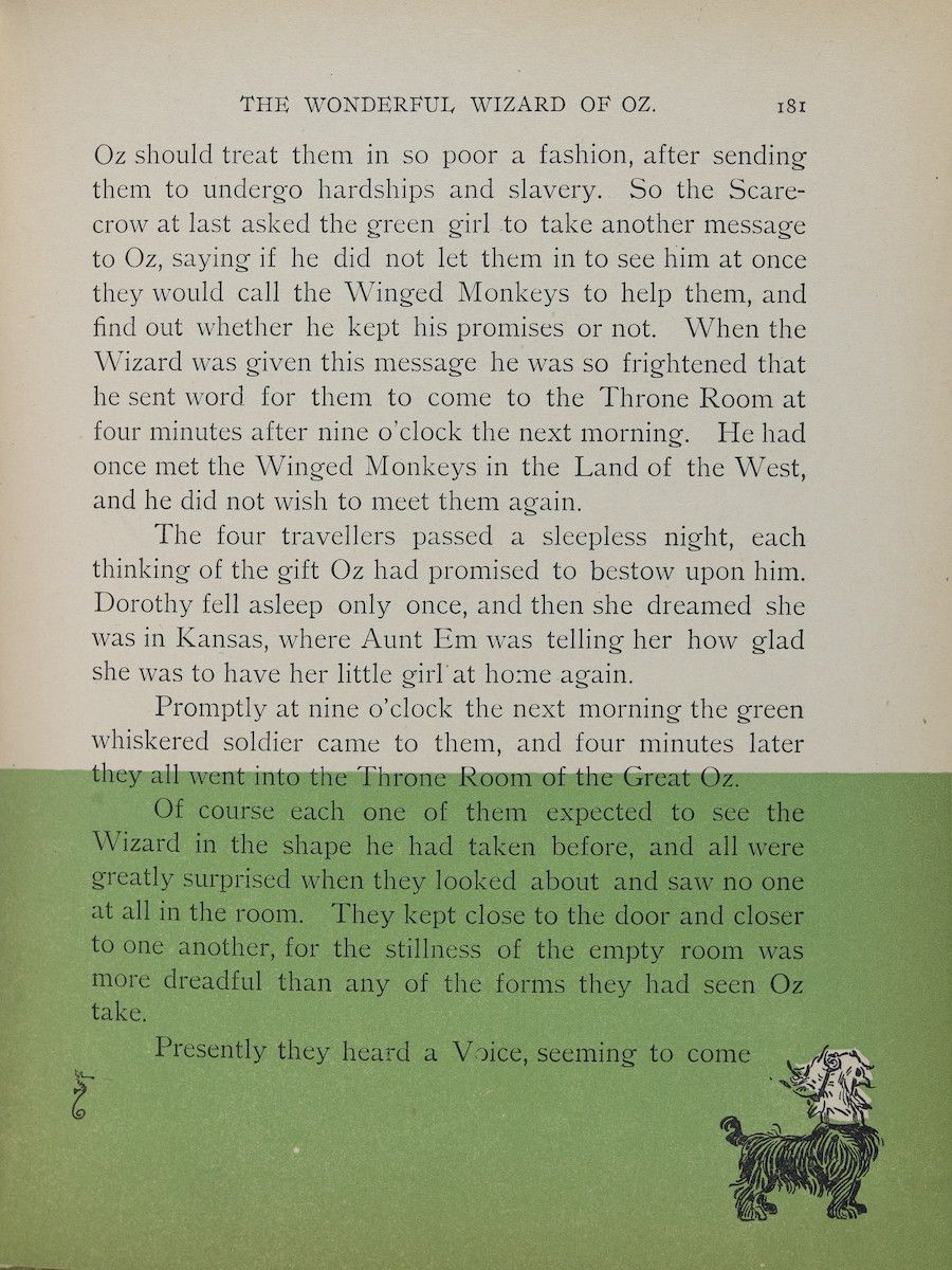 A vintage book page from 'The Wonderful Wizard of Oz' with dense text and a small floral illustration.