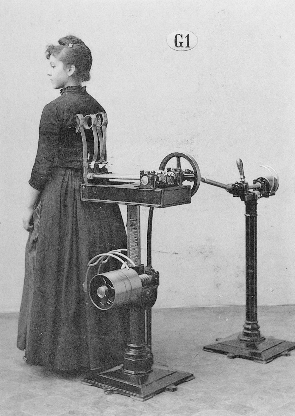 Vintage black and white photograph of a woman operating a complex machine.