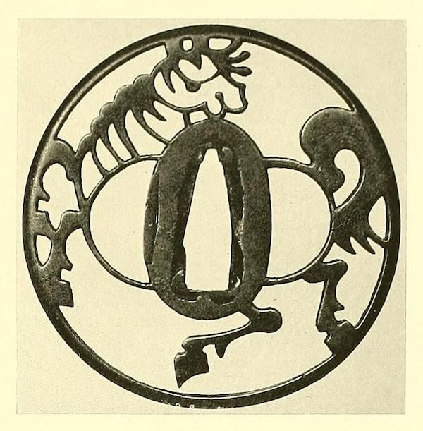 A circular, ornate design featuring a stylized letter 'O' at the center, surrounded by a delicate, lace-like frame.