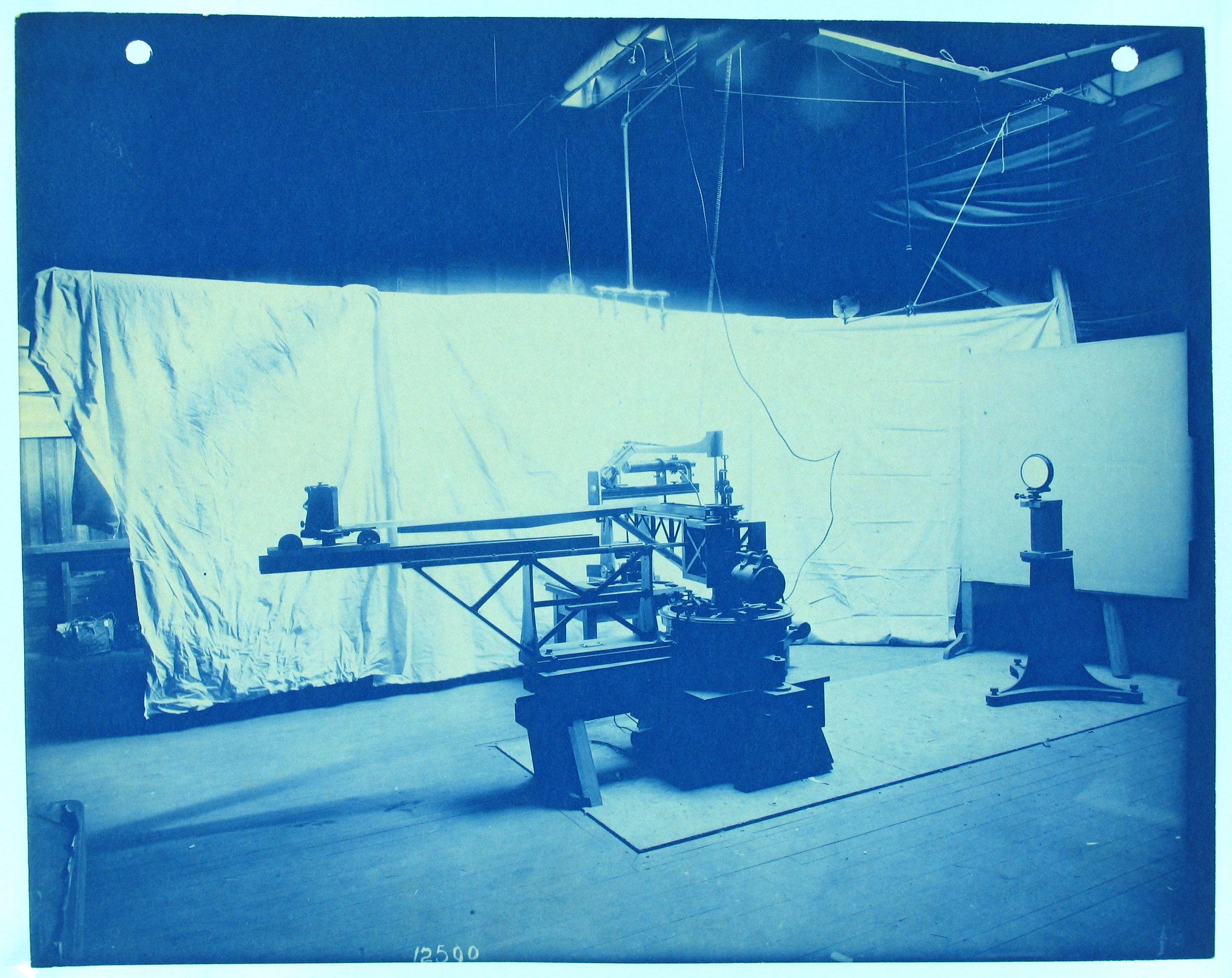 A vintage black and white photograph of a laboratory setting with a complex scientific machine in the center.