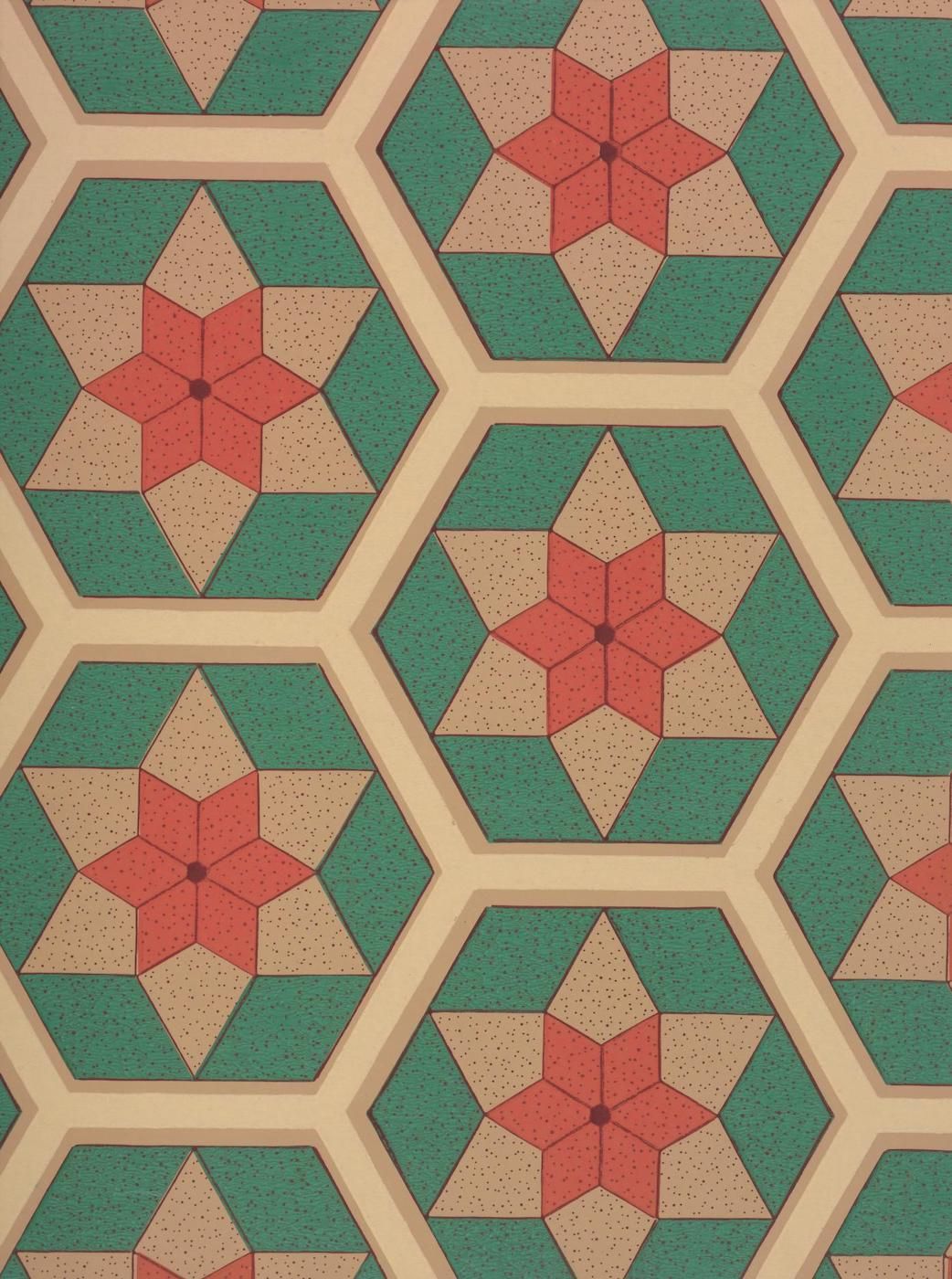 A repeating geometric pattern of hexagons with a central reddish-orange star-like shape and alternating beige and green triangular segments.