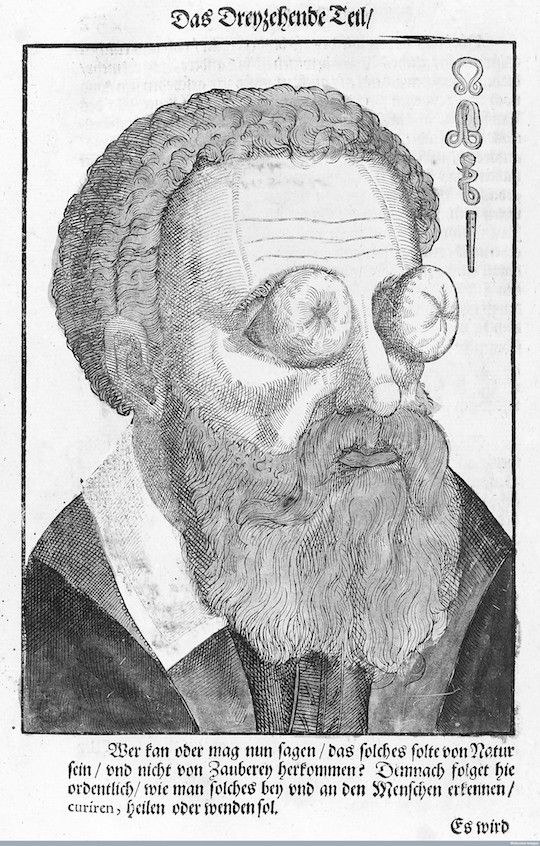 Black and white illustration of a man with a large beard and curly hair, wearing a high-collared garment.