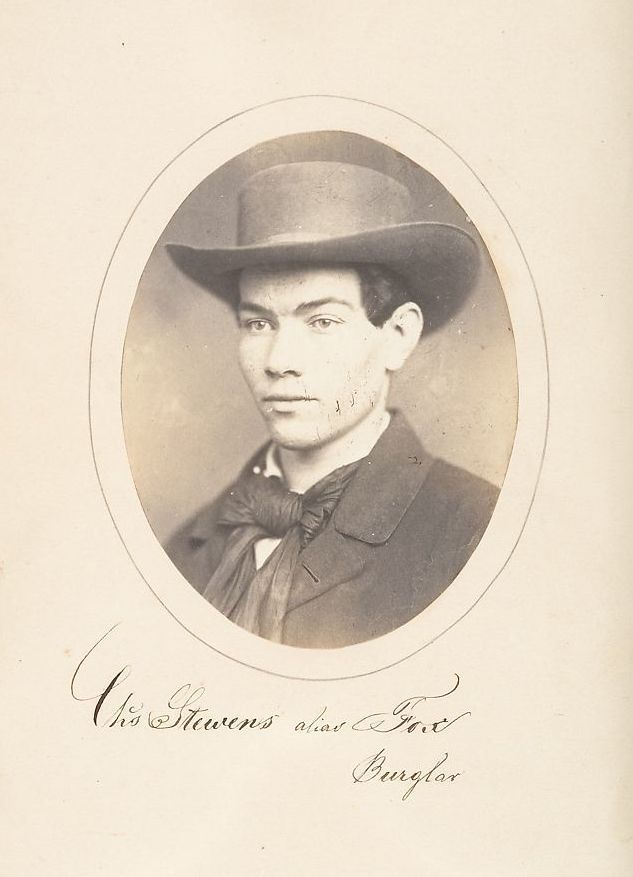 Vintage sepia-toned portrait of a man identified as 'Chas Stevens alias 'Port' Burglar' wearing a hat and formal coat.