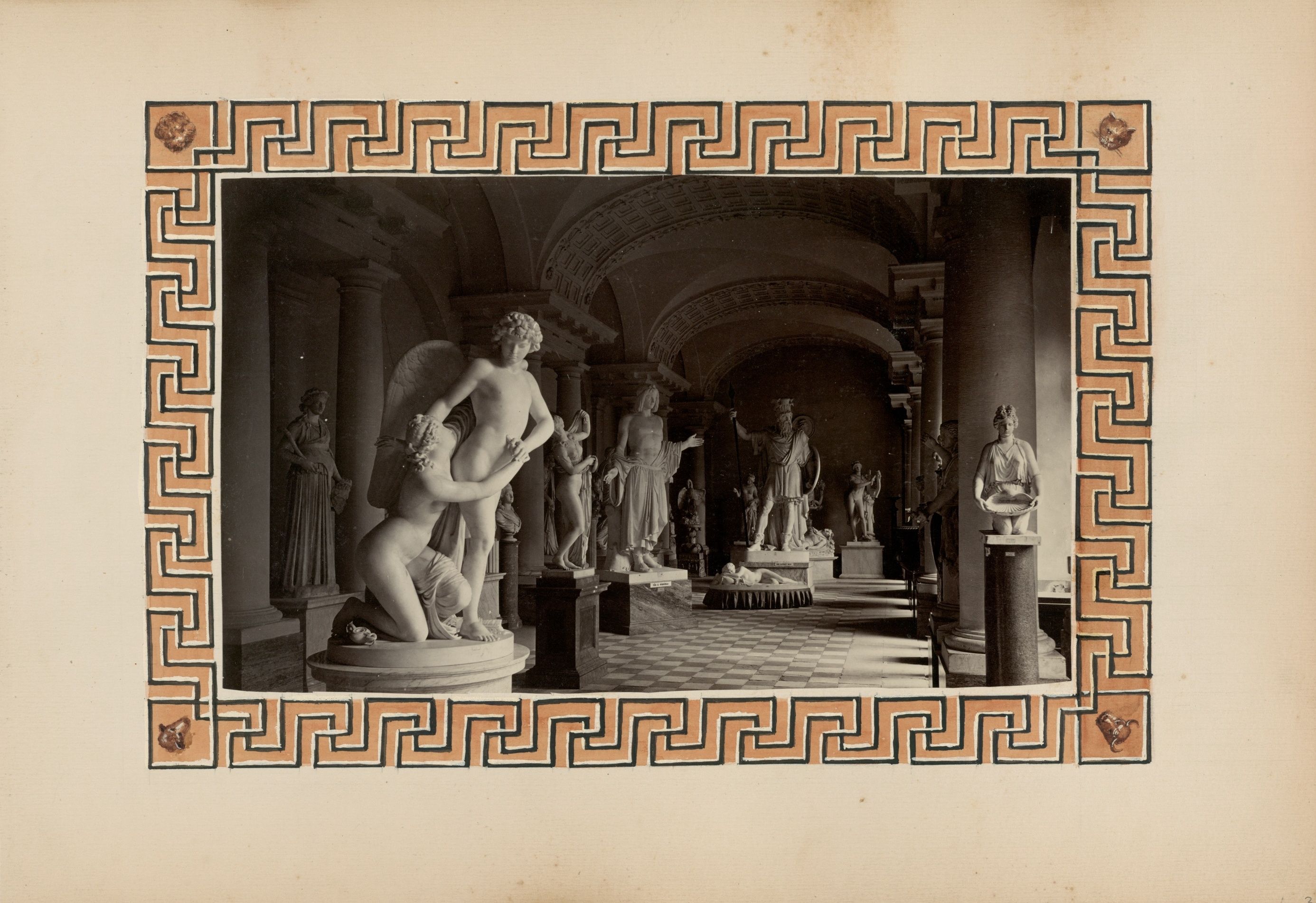 Vintage photograph of a museum hallway filled with classical sculptures, framed by an ornate border.