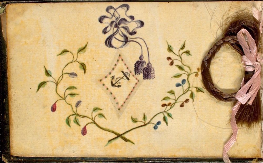 A vintage page with a lock of hair and a hand-painted floral design.