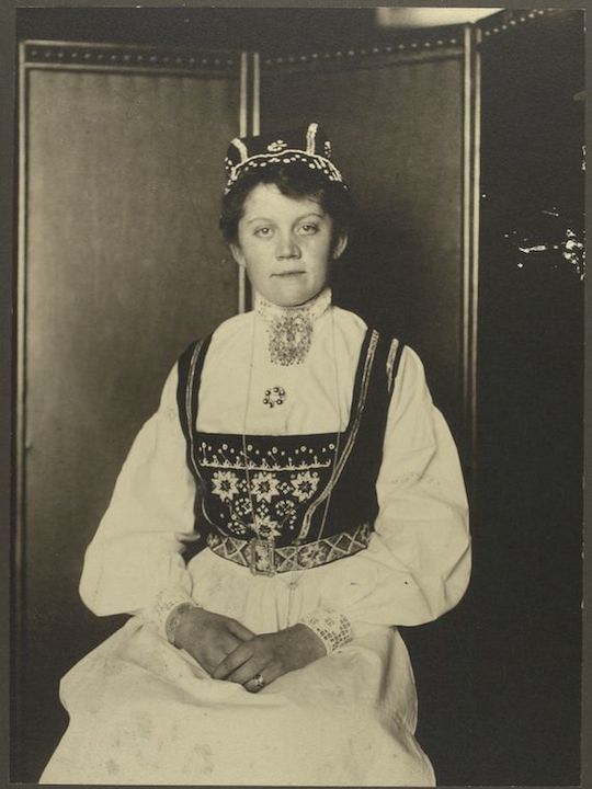 A vintage black and white portrait of a woman in traditional attire.