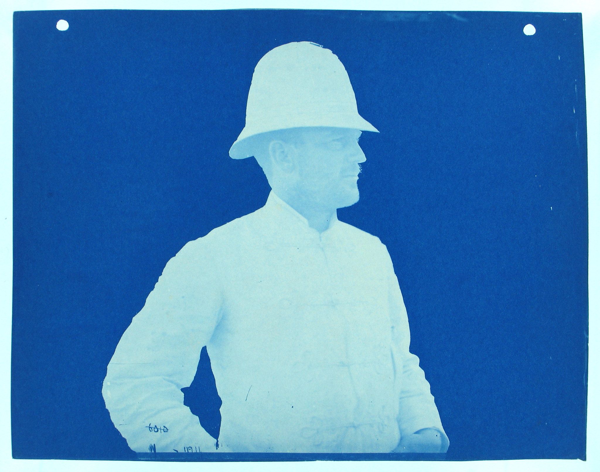 Cyanotype portrait of a man in a pith helmet and military uniform.