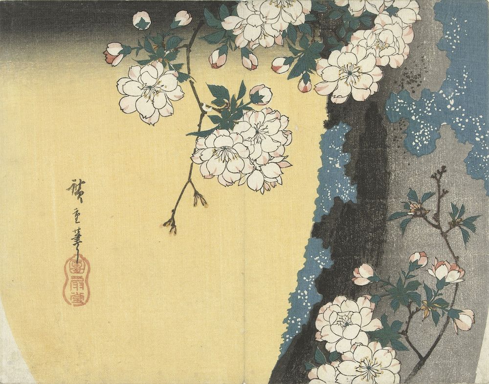 A Japanese woodblock print featuring a flowering branch against a soft yellow background and a dark, textured wall.