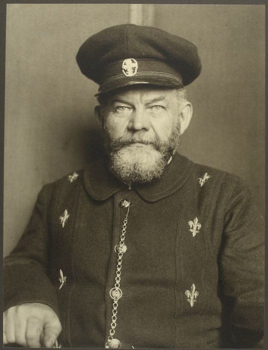 Sepia-toned portrait of an older man in a formal uniform with a full white beard and peaked cap.
