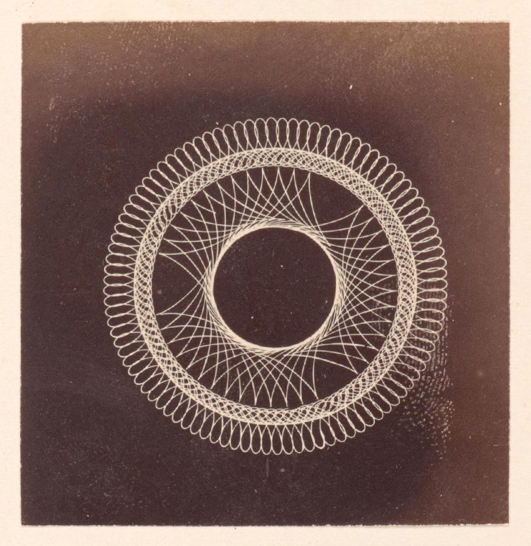 A square-shaped photograph with a dark background and a complex circular pattern created by numerous thin, white lines.