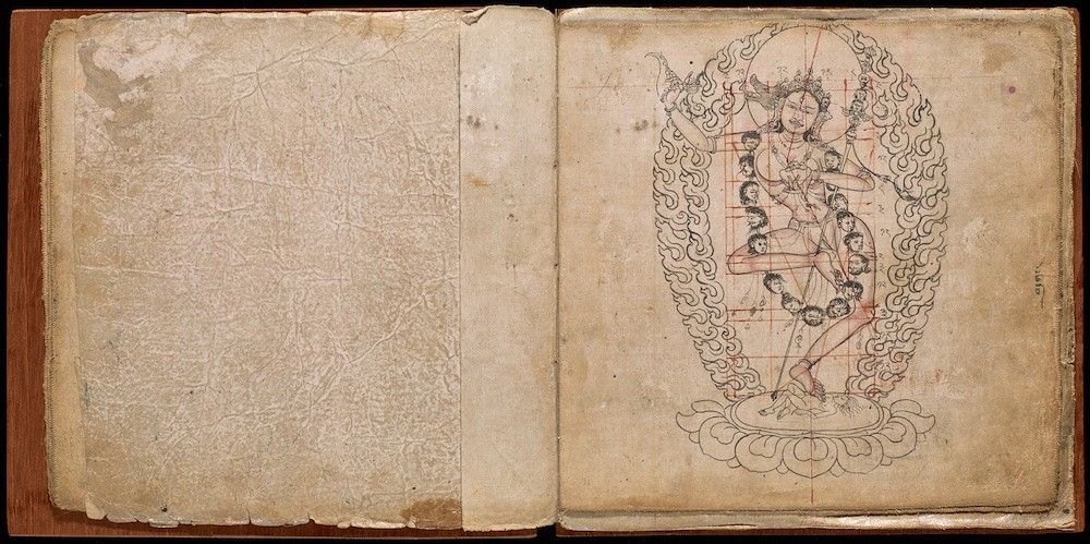 Open book with a drawing of a deity in an ornate frame on the right page.