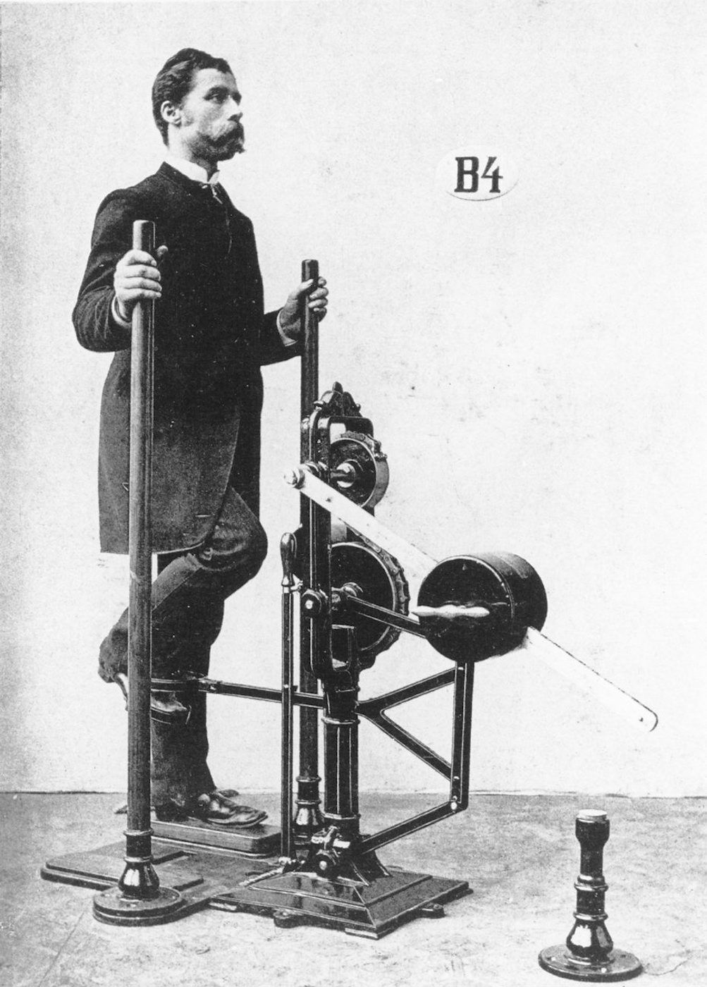 Vintage photograph of a man operating a complex mechanical device.