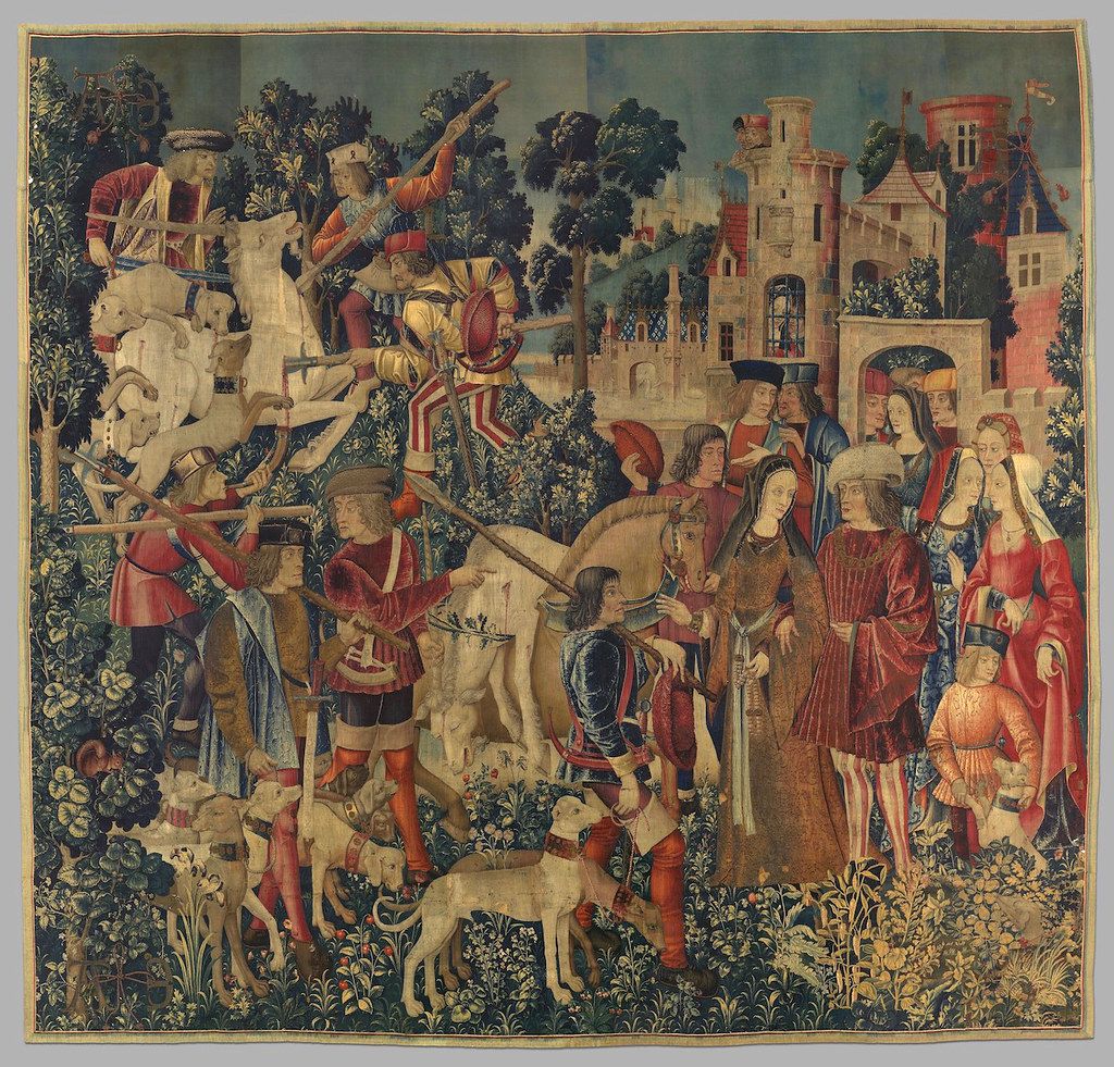 A detailed medieval tapestry depicting a hunting scene with hunters on horseback, dogs, and a castle in the background.