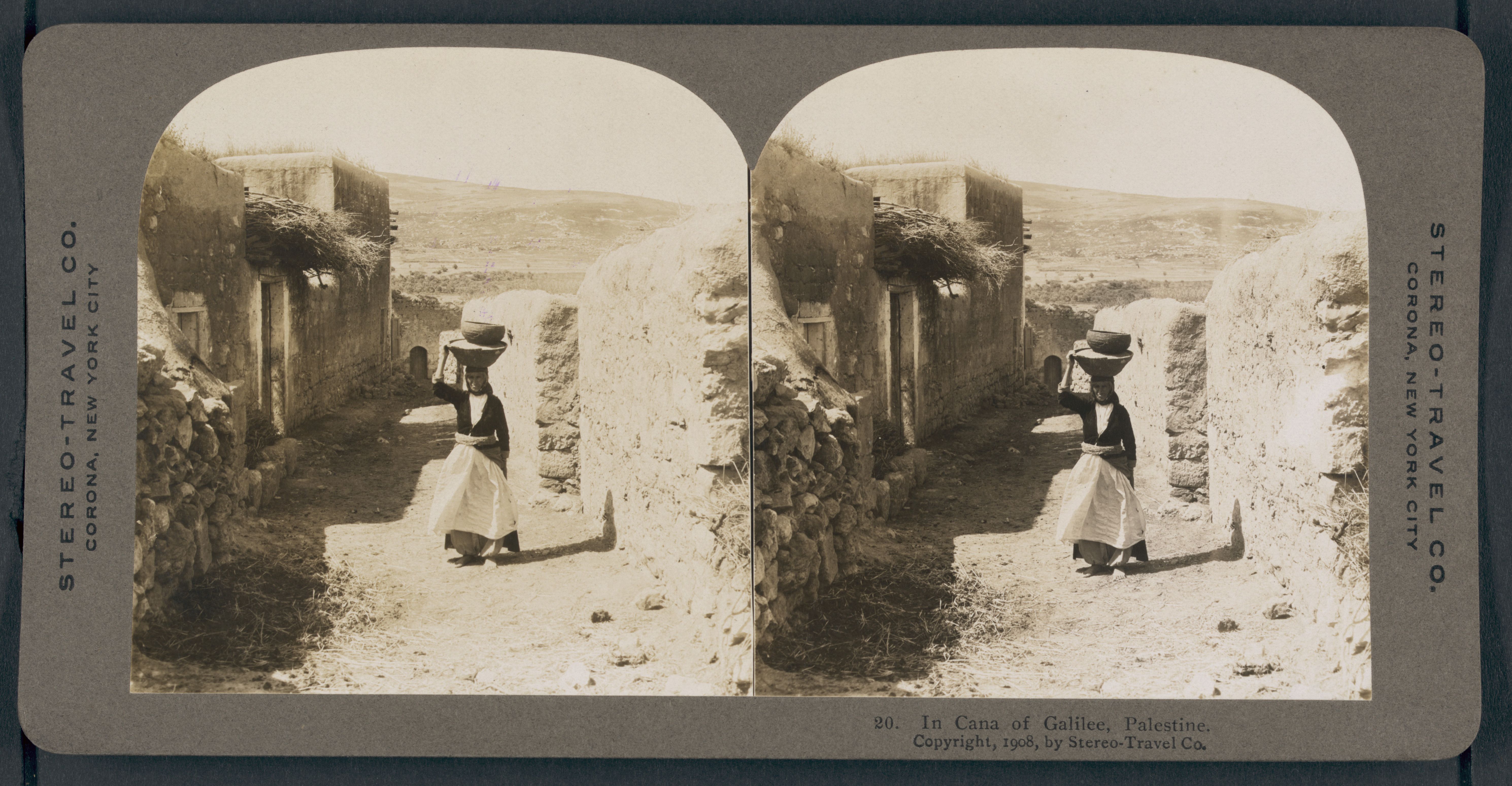 Stereoscopic photograph of a woman carrying a large object on her head in a narrow passageway in Cana of Galilee, Palestine, dated 1908.
