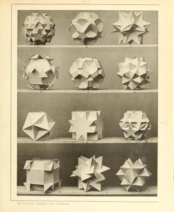 A vintage black and white photograph depicting a series of 12 geometric shapes, likely created through paper folding, arranged in a grid-like pattern.