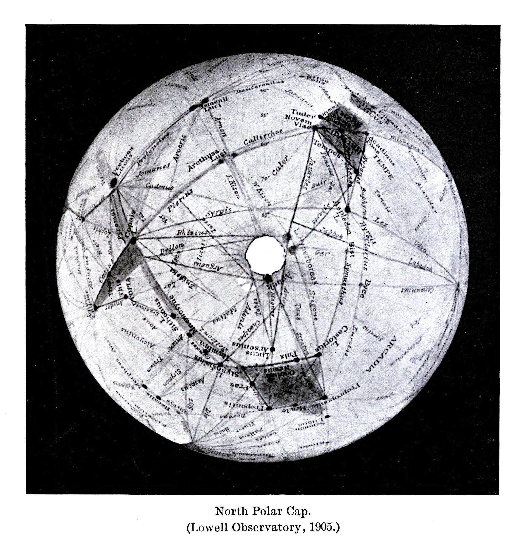 A black and white map of the North Polar Cap, as indicated by the text below the image which reads "North Polar Cap. (Lowell Observatory, 1903.)". The map is a circular projection of the polar region, with a central white circle representing the pole itself. Radiating outwards from the central pole are numerous lines connecting various points on the map, forming a network of triangles and polygons. Scattered across the map are numerous labels and names written in a small, cursive font.