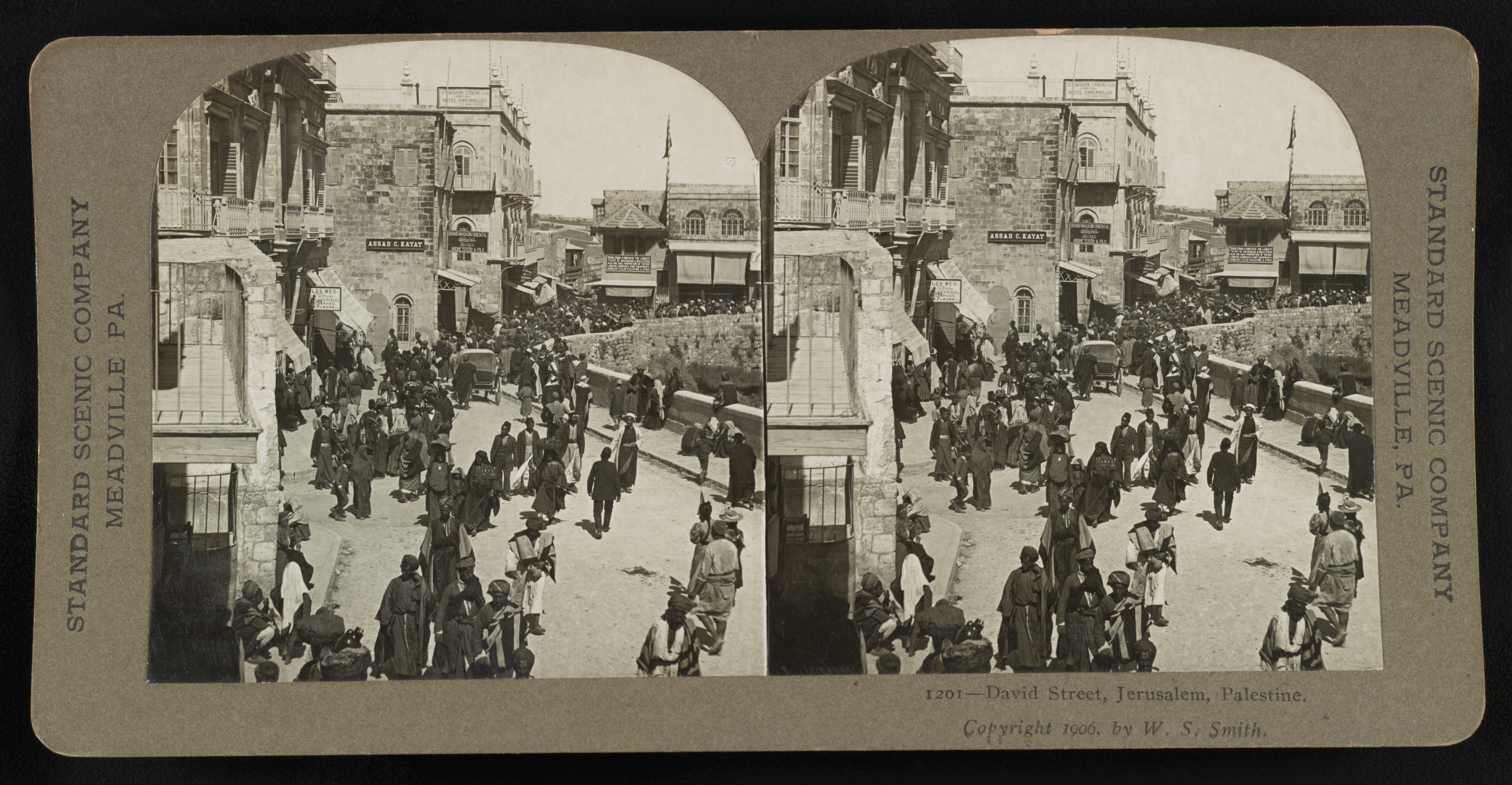 Stereoscopic card of David Street, Jerusalem, Palestine, circa 1906, showing a crowded street scene with people, horses, carriages, and stone buildings.