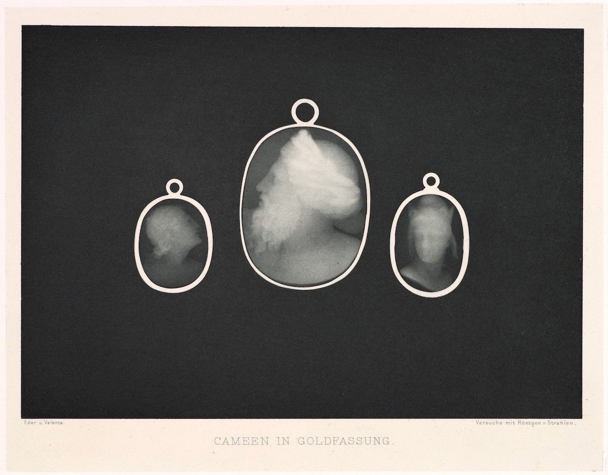 Vintage black and white photograph of a cameo in a gold setting, captured using X-ray technology.