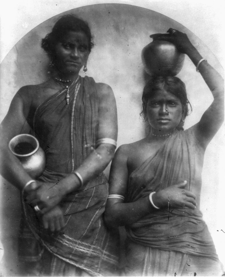 Vintage black and white photograph of two Indian women carrying clay pots.