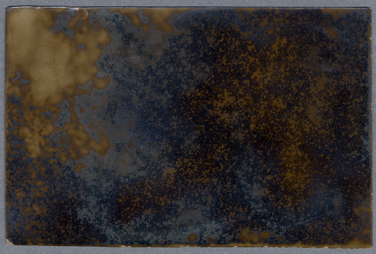 A textured surface with a gradient of color, transitioning from golden-brown on the left to deep navy blue on the right.