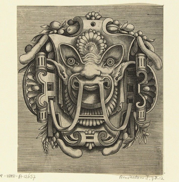 Detailed black and white engraving of an ornate, symmetrical design resembling a mask or face with floral and scrollwork ornamentation.
