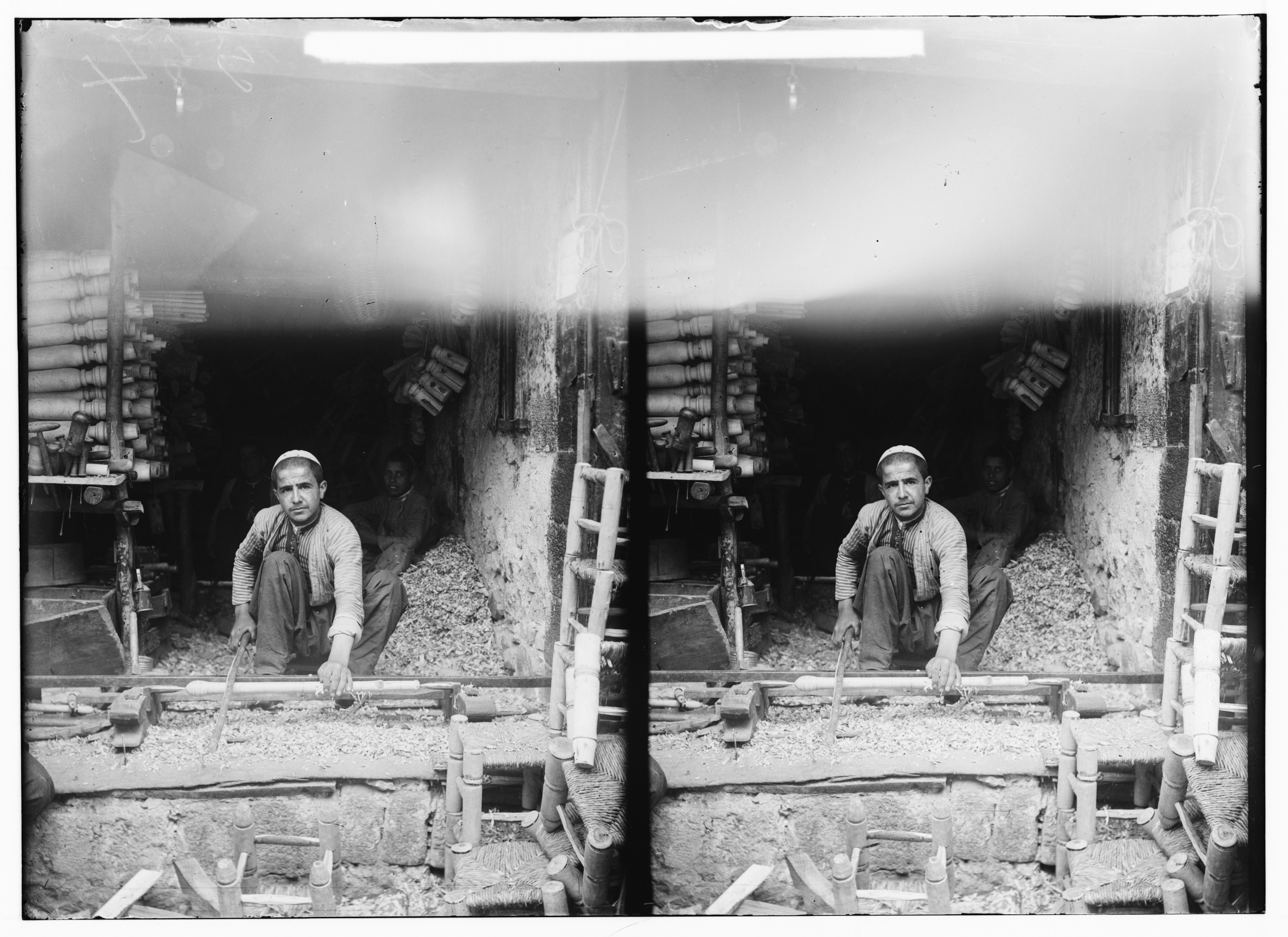 Stereoscopic photograph of a man working at a wooden structure, likely a mill or workshop.