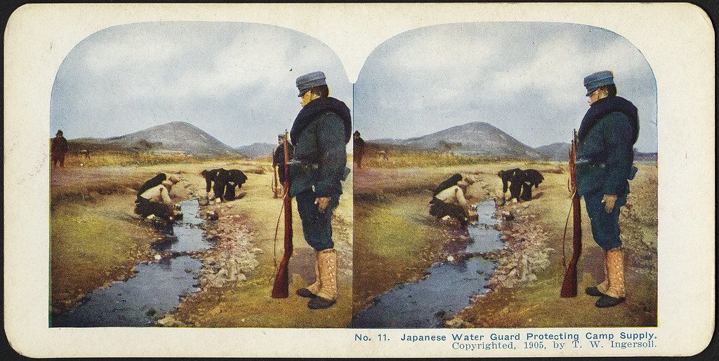 Stereoscopic photograph of a Japanese water guard protecting a camp supply in 1905.