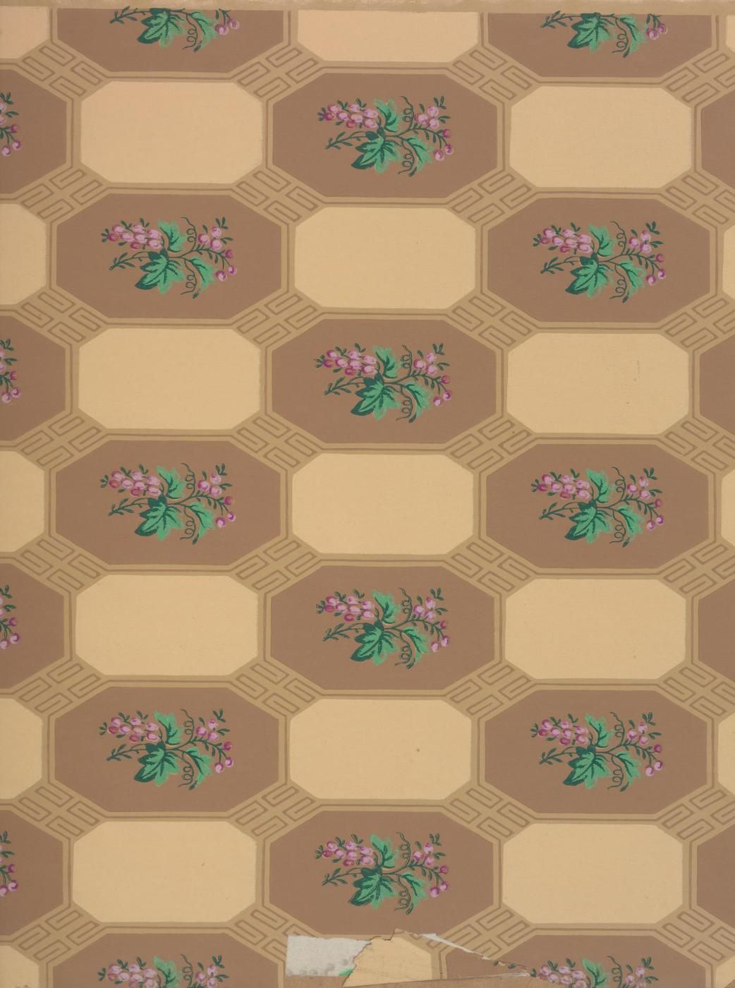 Close-up of a vintage wallpaper with a repeating pattern of octagons containing floral arrangements in pink and green against a brown background.
