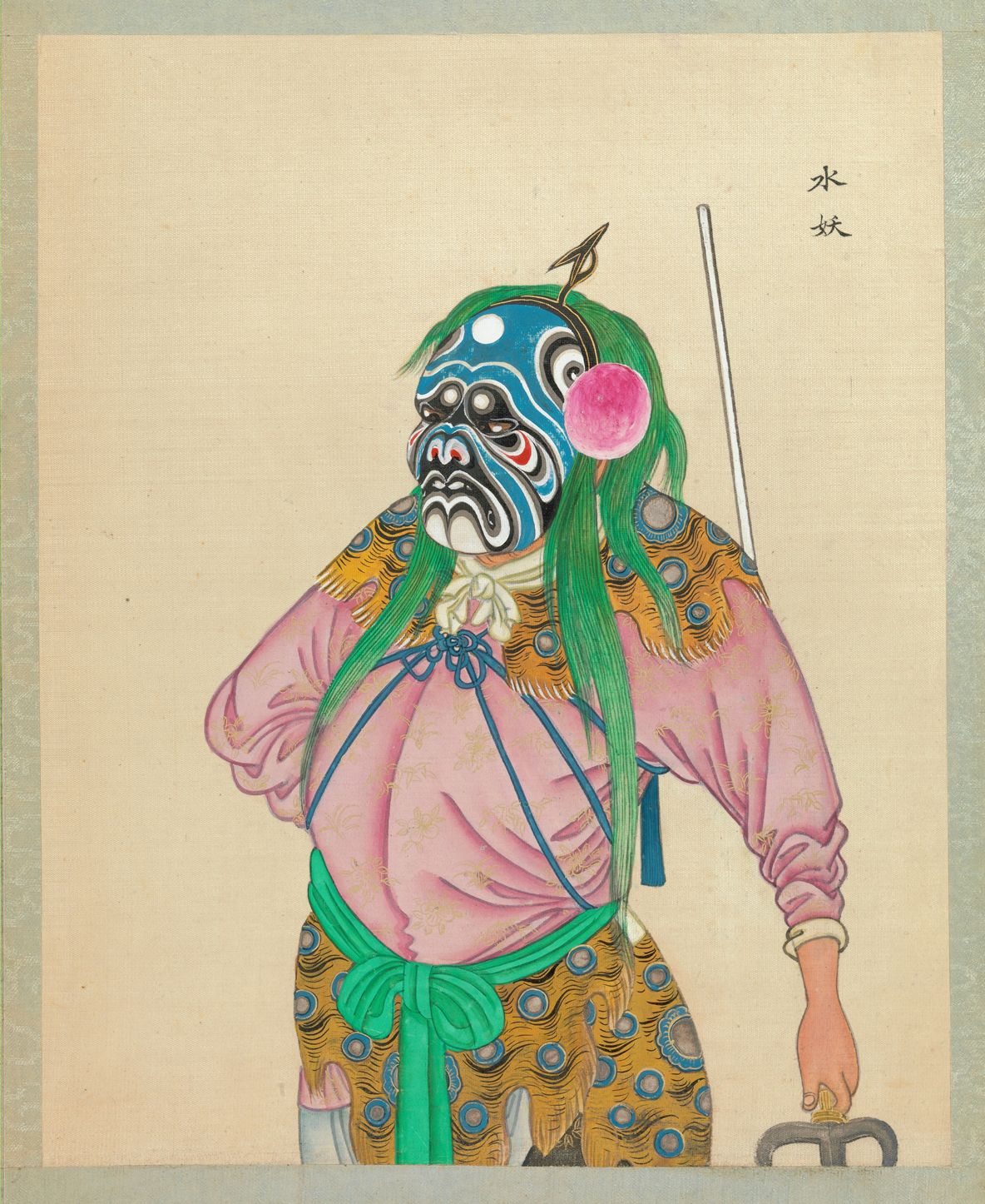 A full-body portrait of a figure in elaborate theatrical costume, likely from Chinese opera, wearing a blue mask with green hair and a pink tunic.