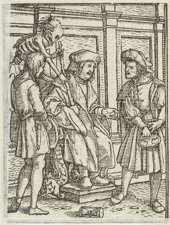 A black and white woodcut image depicting a scene with several figures. An older man is seated on a raised chair, with two younger men attending to him. A skeletal figure descends from the ceiling, and another man stands holding shoes. The scene takes place indoors with a skull and cylindrical object on the floor.