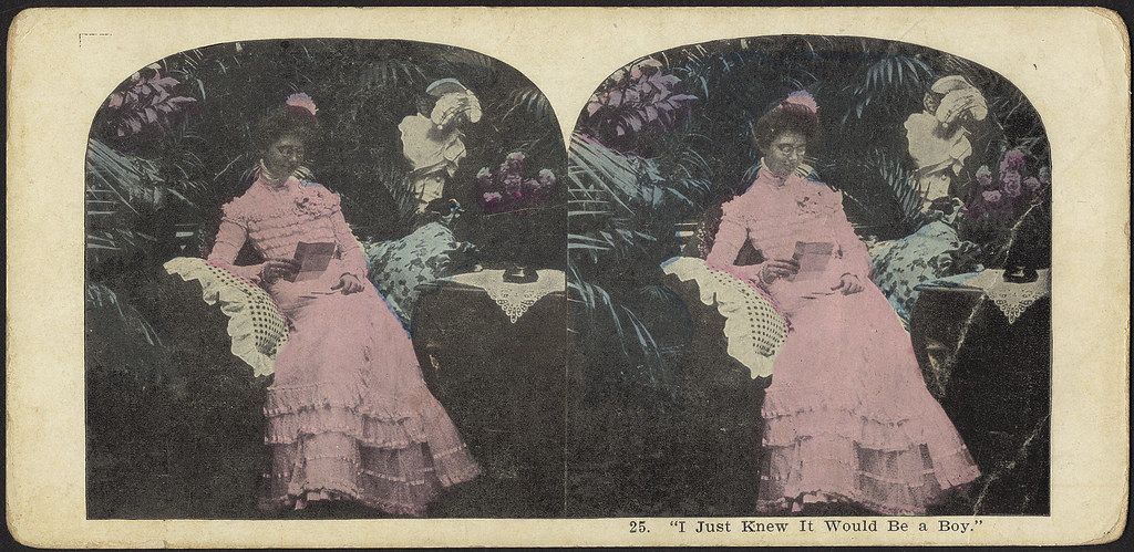 Stereoscopic card depicting a woman in a pink dress holding a fan and wearing a hat, labeled 'I Just Knew It Would Be a Boy.'