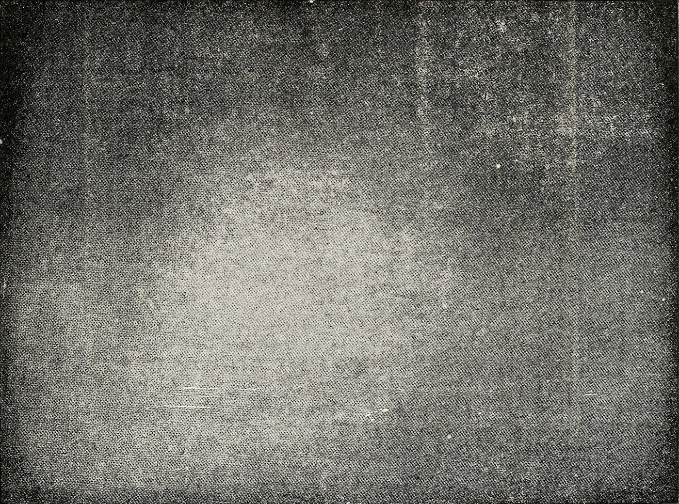 A grainy, dark textured surface with a vignette effect.