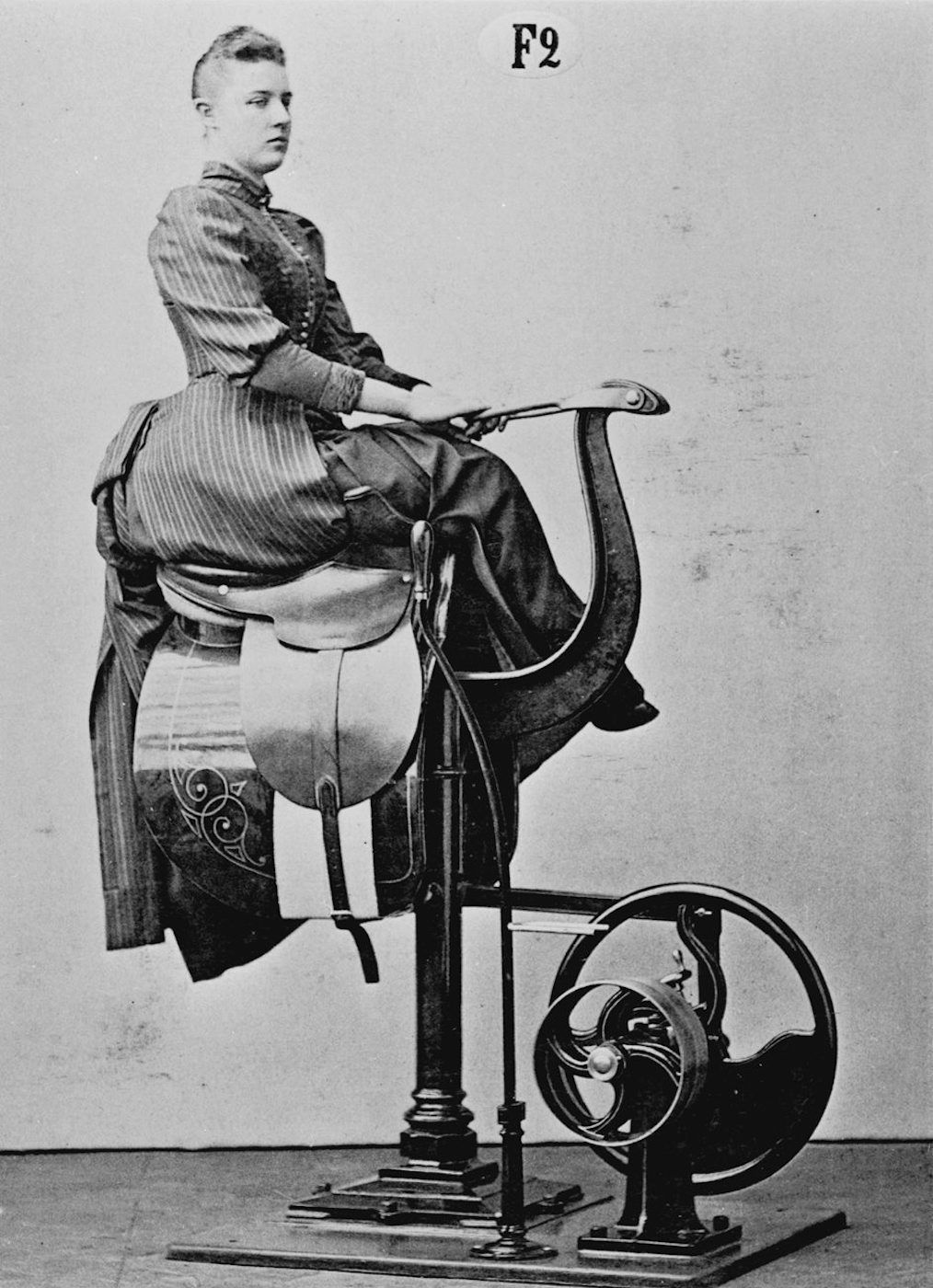 Vintage photograph of a young man on a mechanical horse.