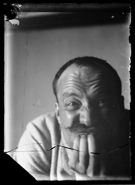 A vintage black and white portrait of a man with a thoughtful expression, his hand resting on his chin.