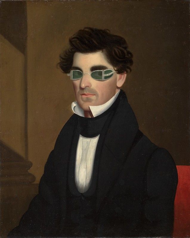 Portrait of a man wearing green tinted glasses.