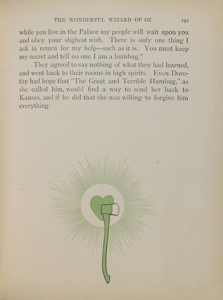 A page from 'The Wonderful Wizard of Oz' with an illustration of a green heart-shaped object with a mechanical device on top.