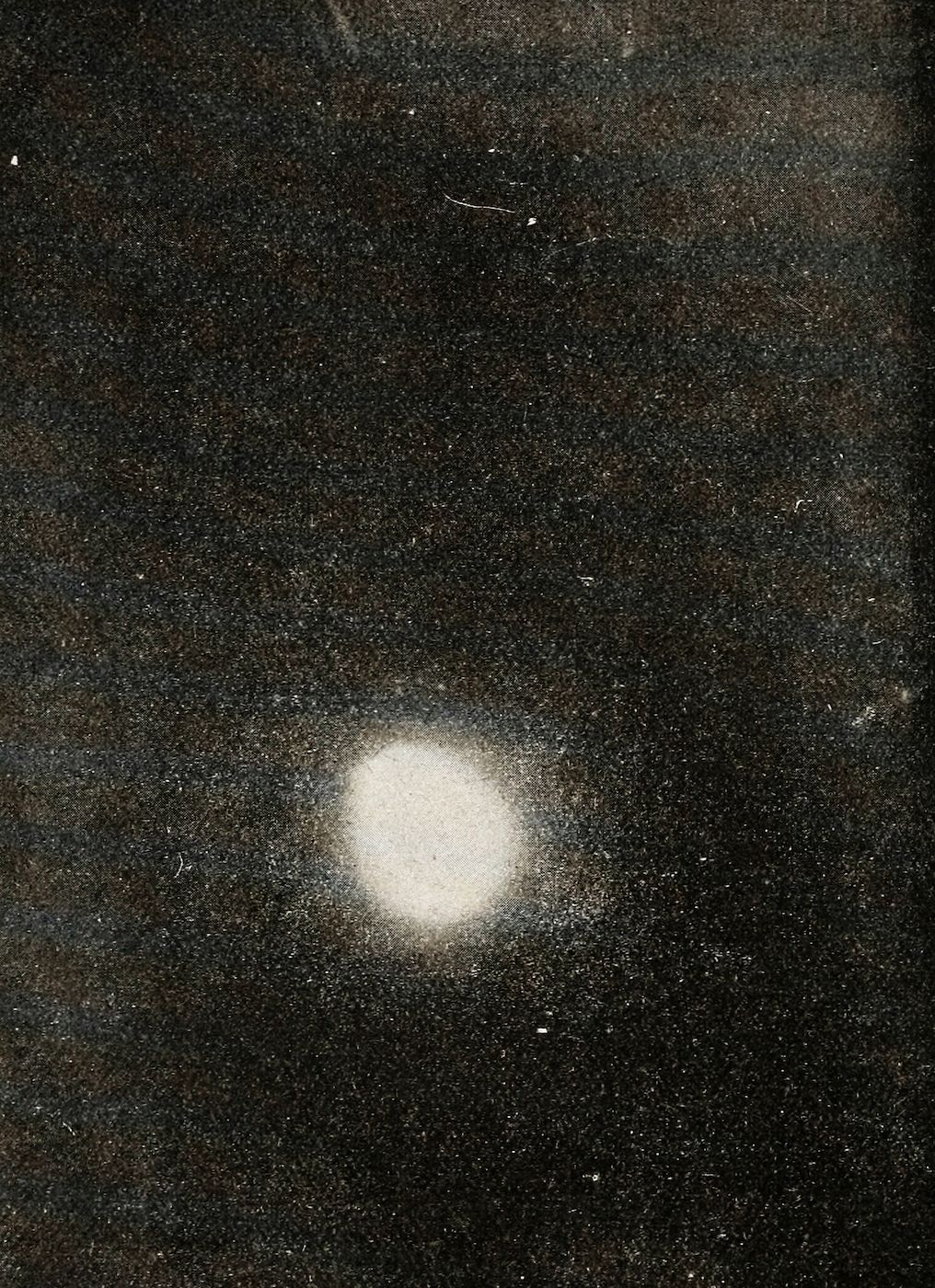 Vintage astronomical photograph of a bright star or galaxy surrounded by a field of distant stars and dust.
