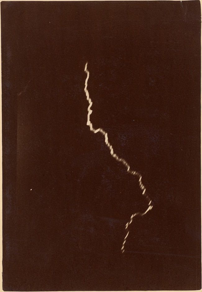 A black and white photograph of a lightning strike against a dark background.