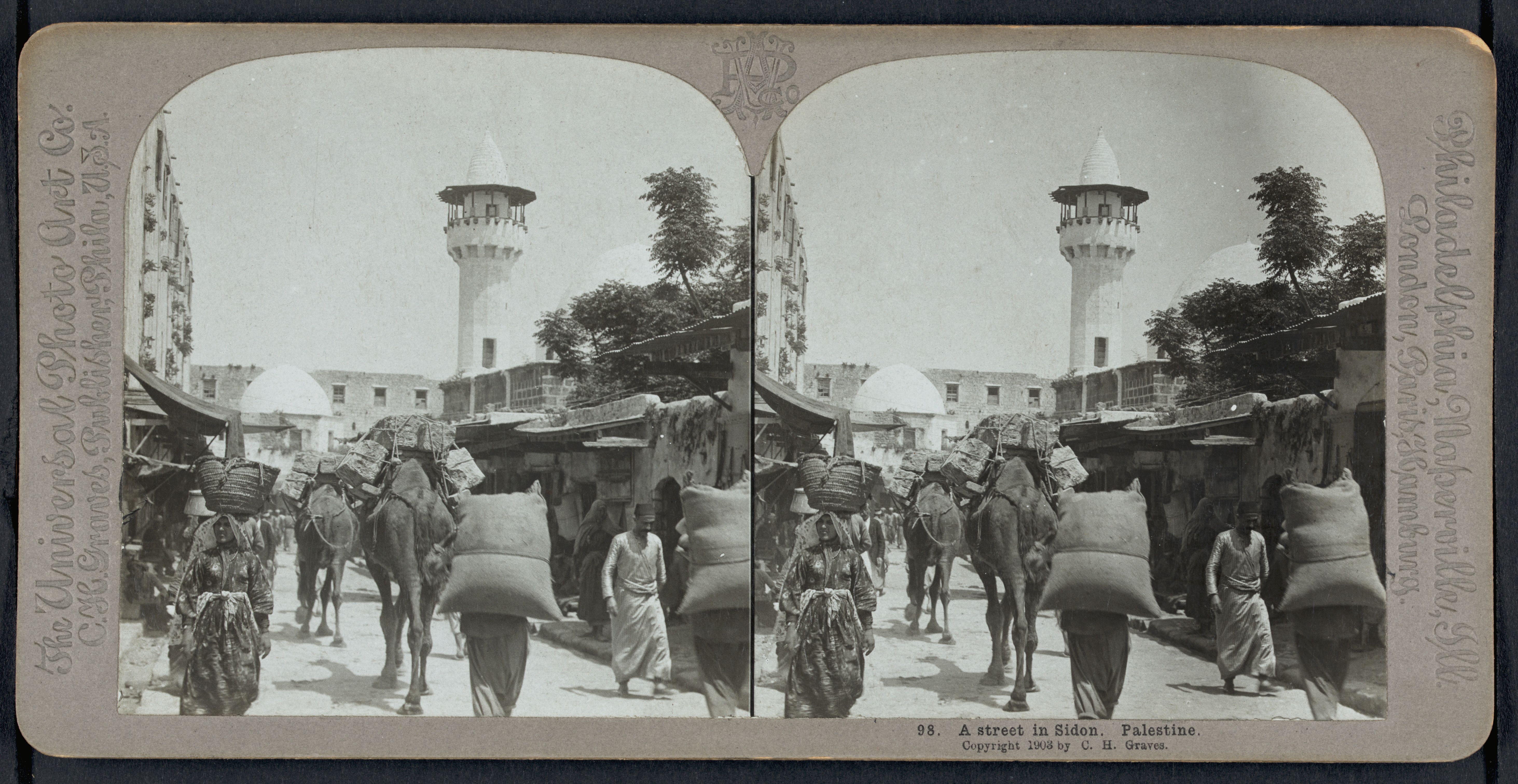 Stereoscopic photograph of a street in Sidon, Palestine, from 1908, showing a crowded street with people, horses, donkeys, and traditional stone buildings.