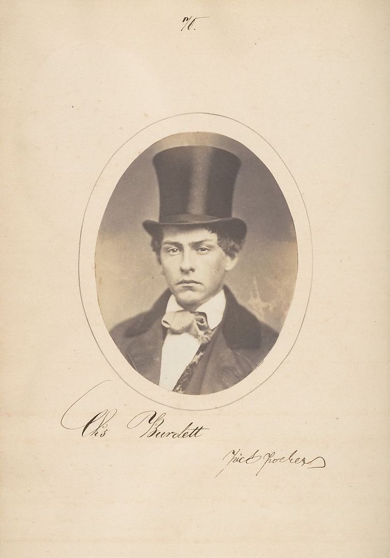 A sepia-toned portrait of a young man in formal attire, including a top hat and bow tie, with handwritten signatures below.