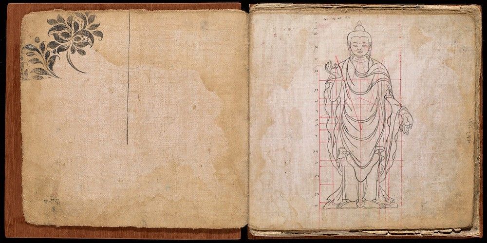 Open book with a sketch of Buddha on the right page and a floral design on the left.