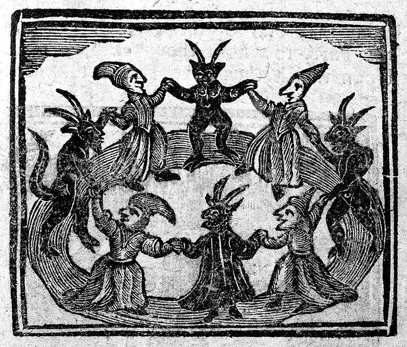 A black and white woodcut-style image depicting a group of seven figures holding hands in a circle. The figures are stylized and appear to be demonic or monstrous, with pointed hats, horns, and tails.