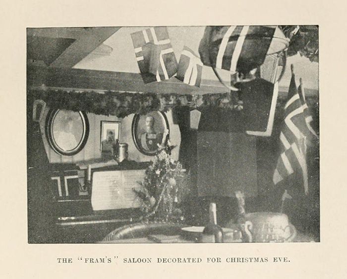 A black and white photograph of a saloon decorated for Christmas Eve. The saloon is adorned with garlands, ribbons, and ornaments. Bottles and glasses are visible on the counter, and mirrors are present on the walls.