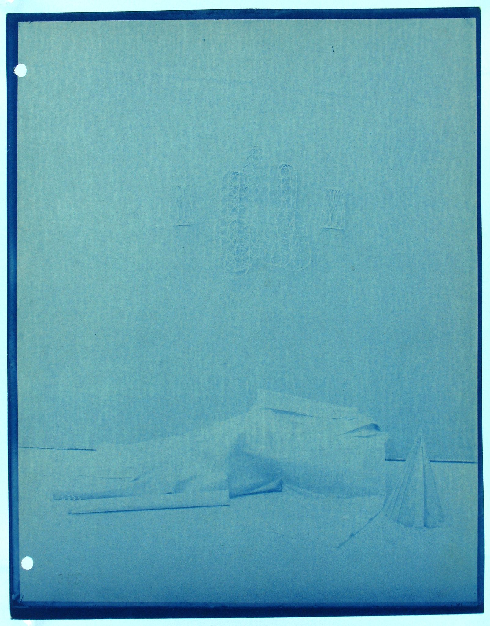 A cyanotype photograph with faint images of a vase and objects on a flat surface.