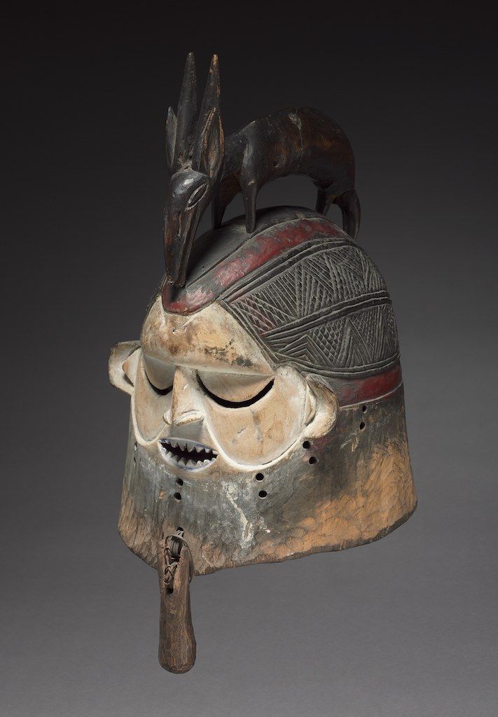 A detailed image of an African mask with a dark, weathered surface and stylized features.