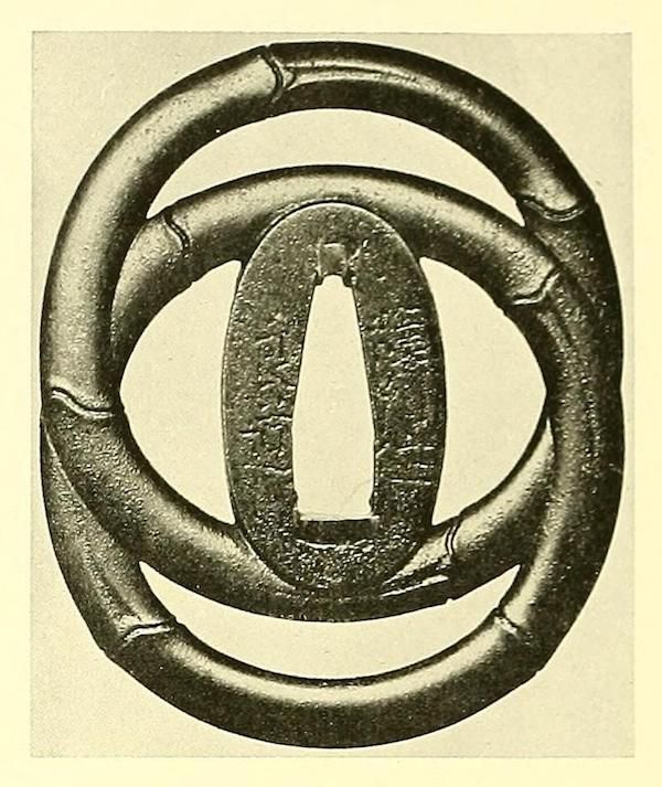 A detailed image of a Japanese tsuba, a sword guard, featuring a design of bamboo stalks arranged in a circular pattern around a central opening.