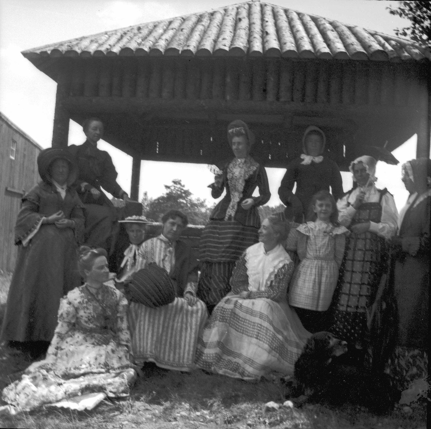 A black and white photograph of a group of women gathered under a gazebo in the early 20th century.